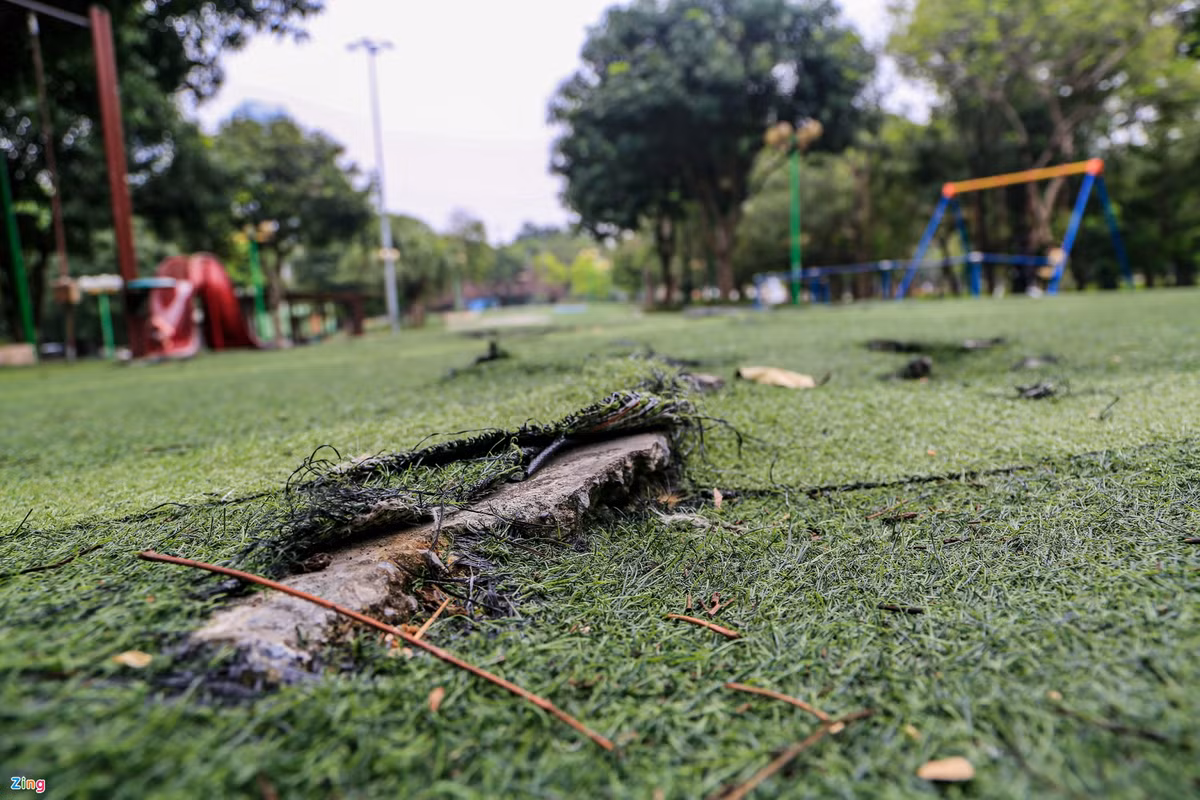 Trên thảm cỏ nhân tạo có nhiều vị trí bị rách, bong tróc mảng lớn. Các miếng bê tông cứng bị lồi lên tạo thành bẫy nguy hiểm.