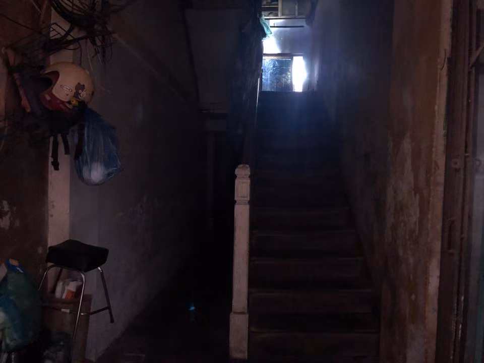 Lối đi chung thiếu không khí và ánh sáng, trên tường có từng mảng tường bị bong tróc, chằng chịt dây điện, ống nước. 