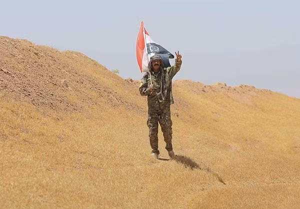 Một chiến binh tình nguyện Iraq giơ tay biểu tượng chiến thắng. Ảnh: FNA.