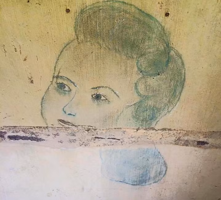 Hình vẽ trên tường khuôn mặt một người phụ nữ với kiểu tóc từ những năm 1940 trong trại giam. Ảnh: The Sun.