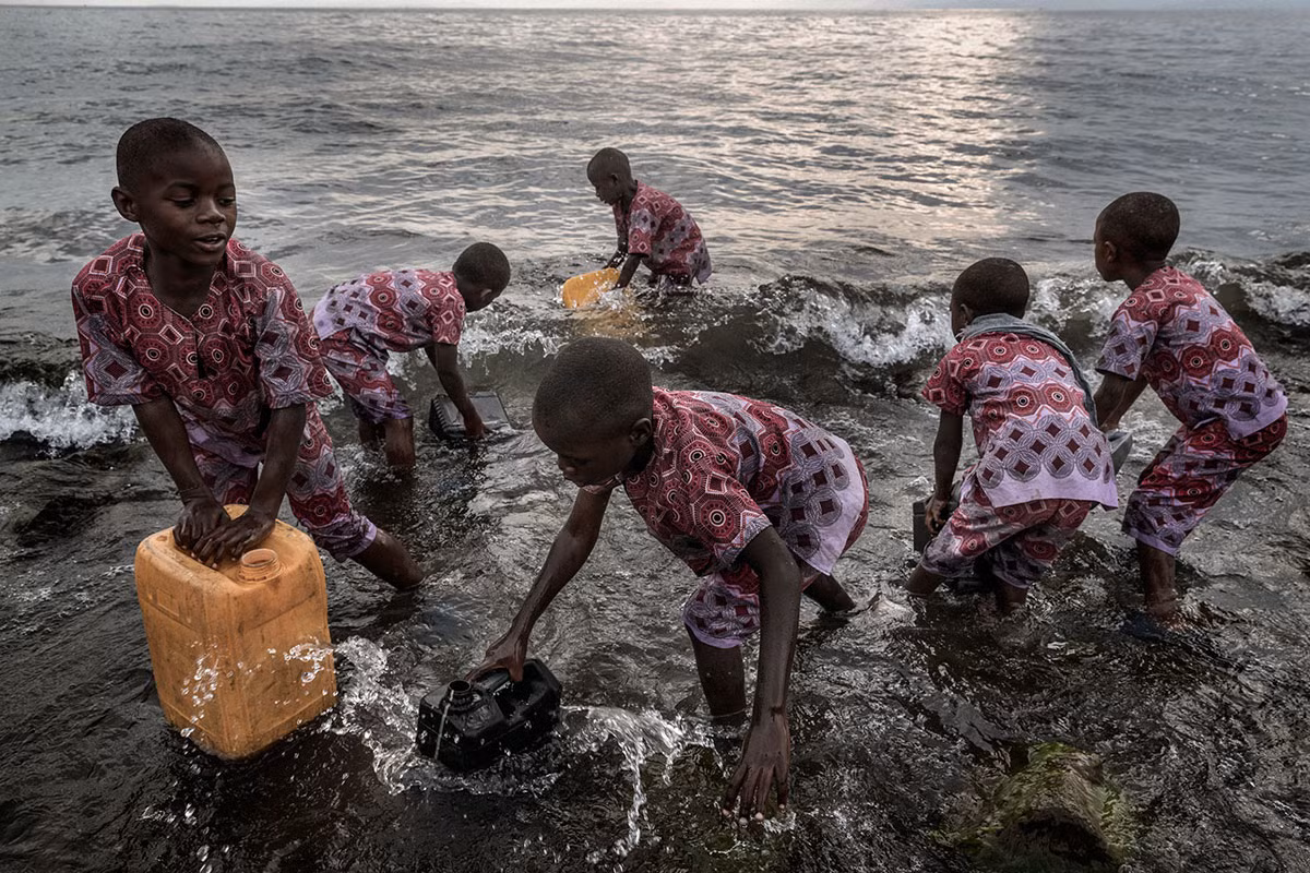 Các em nhỏ đến từ trại mồ côi Tulizeni ở Goma tới hồ Kivu để lấy nước mỗi ngày. Được biết, trung tâm này đã tiếp nhận 74 bé gái và 200 phụ nữ bị lạm dụng tình dục trong ba năm qua.