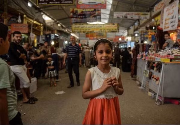 Một bé gái cười tươi trong khu chợ Prophet Younis ở Đông Mosul. Ảnh: FNA.