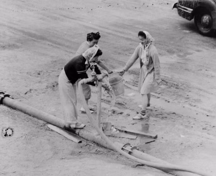 Những người phụ nữ lấy nước trong trại Manzanar. Ảnh: ATI.