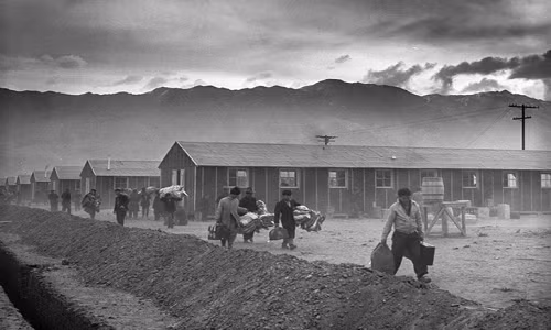 Nhóm đầu tiên gồm 82 người Mỹ gốc Nhật mang theo đồ đạc đến trại giam Manzanar ở California (Mỹ) ngày 21/3/1942, trong thời kỳ Chiến tranh Thế giới thứ hai. Ảnh: ATI.