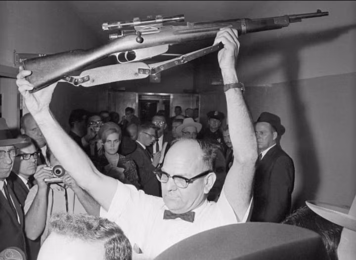 Cảnh sát Dallas cầm khẩu súng trường mà Lee Harvey Oswald được cho là đã sử dụng để sát hại Tổng thống Kennedy. Ảnh: ATI.