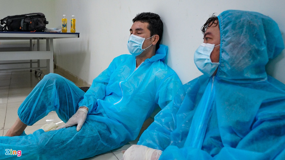  Hoàng Phi Kha: Nam diễn viên và đồng nghiệp là Peter Phạm chợp mắt ở một góc tường lúc nghỉ giải lao. Phi Kha là diễn viên đầu tiên tham gia đội ngũ tình nguyện viên. Hai tháng qua, anh làm việc ngày đêm ở nhiều "mặt trận": hỗ trợ nhân viên y tế lấy mẫu xét nghiệm, dọn dẹp khu ký túc xá để làm nơi cách ly, tiêm vắc xin COVID-19, đi siêu thị giúp người dân... Ảnh: Phương Lâm.