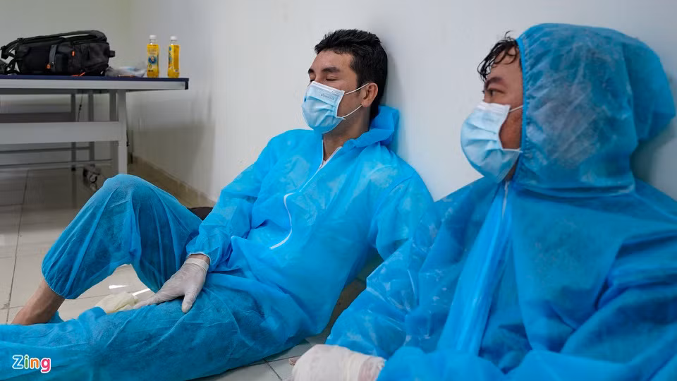  Hoàng Phi Kha: Nam diễn viên và đồng nghiệp là Peter Phạm chợp mắt ở một góc tường lúc nghỉ giải lao. Phi Kha là diễn viên đầu tiên tham gia đội ngũ tình nguyện viên. Hai tháng qua, anh làm việc ngày đêm ở nhiều "mặt trận": hỗ trợ nhân viên y tế lấy mẫu xét nghiệm, dọn dẹp khu ký túc xá để làm nơi cách ly, tiêm vắc xin COVID-19, đi siêu thị giúp người dân... Ảnh: Phương Lâm.