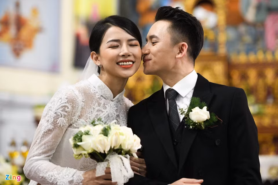 Khánh Vy chọn kiểu tóc búi gọn sau gáy, lớp trang điểm tông nude đơn giản nhưng tôn đường nét khuôn mặt thanh tú của cô. Áo dài cũng được thiết kế gọn gàng, giúp cô dâu dễ di chuyển.