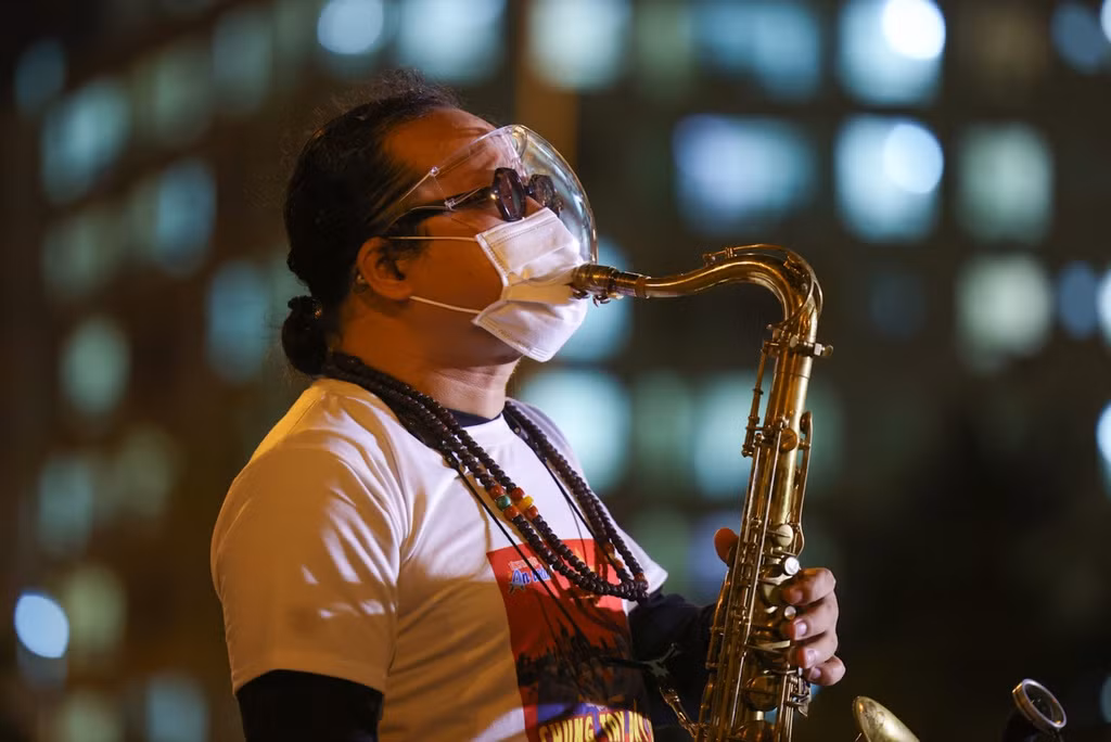 Vợ và con nghệ sĩ Trần Mạnh Tuấn đã chỉnh sửa chiếc khẩu trang để ông có thể biểu diễn kèn saxophone nhưng vẫn tuân thủ nguyên tắc 5K phòng chống dịch bệnh.