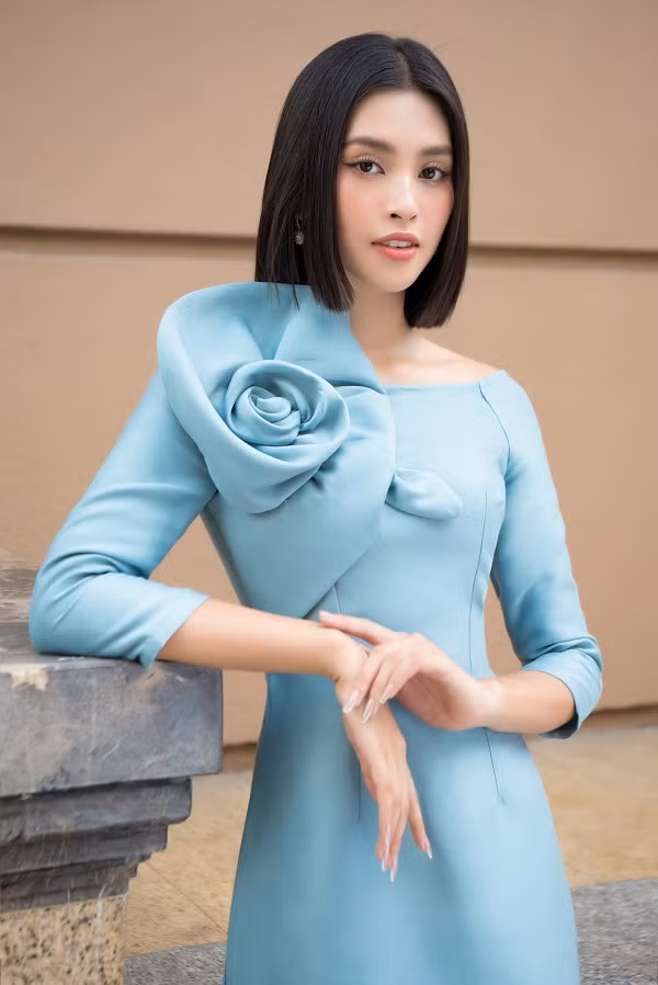 Trong một thiết kế khác, điểm nhấn của chiếc áo dài lại dồn hết vào chi tiết bông hoa được làm cùng chất liệu, đính ở cầu vai.