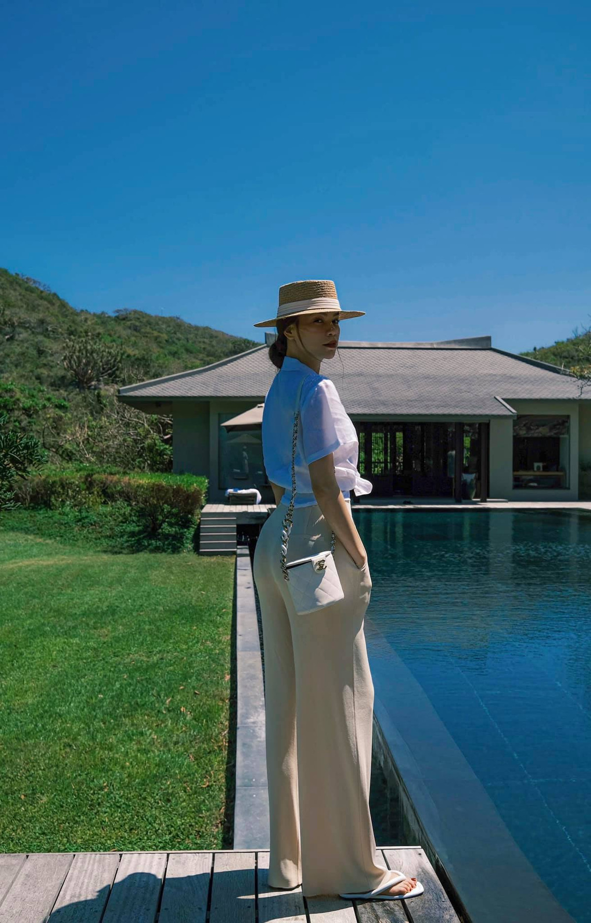 Ở loạt ảnh khác, Hồ Ngọc Hà diện trang phục sành điệu, phối túi Chanel, khoe vòng 3 cong vút bên bể bơi.