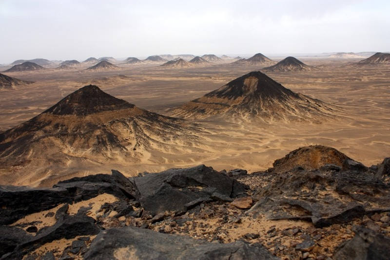  Sa mạc đen Ai Cập: Ai Cập là vùng đất sở hữu nhiều cảnh tượng thiên nhiên, công trình cổ đại hùng vỹ. Chỉ tính riêng sa mạc, vùng đất này đã có hai loại ở thái cực khác nhau: sa mạc đen và trắng. Sa mạc đen cách sa mạc trắng khoảng 100 km về phía Đông Bắc. Màu đen của cát được hình thành bởi các vụ núi lửa phun trào. Du khách thường bắt gặp những tảng đá đen lẫn xen kẽ cùng những viên đá nâu vàng. 