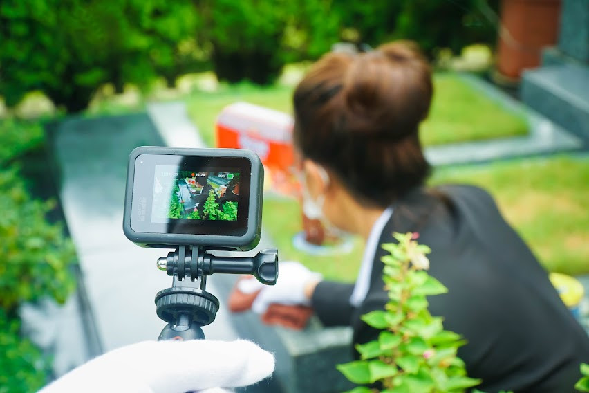 Bên kia đầu dây kết nối: "Cháu chào cô và toàn thể gia đình, cháu là Văn Quỳnh - nhân viên Công viên Tâm linh Lạc Hồng Viên. Chúng cháu đã sắm lễ theo nguyện vọng của gia đình. Sau đây là toàn cảnh buổi lễ, cháu xin được chia sẻ qua video trực tuyến tới toàn thể gia đình mình". 