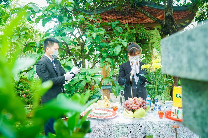 Bên kia đầu dây kết nối: "Cháu chào cô và toàn thể gia đình, cháu là Văn Quỳnh - nhân viên Công viên Tâm linh Lạc Hồng Viên. Chúng cháu đã sắm lễ theo nguyện vọng của gia đình. Sau đây là toàn cảnh buổi lễ, cháu xin được chia sẻ qua video trực tuyến tới toàn thể gia đình mình". 