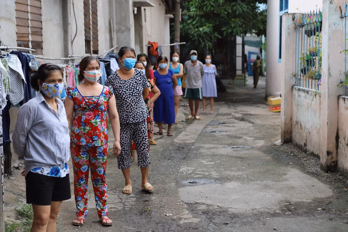 Người dân đứng chờ tới lượt để được cấp lương thực, thực phẩm.