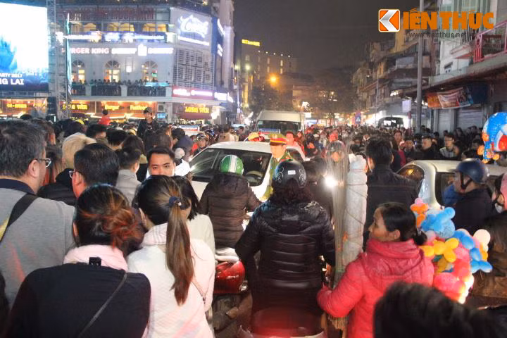 Ở các con phố lân cận, dòng người đi bộ, xe máy, ô tô... di chuyển không theo phân làn. Cảnh tượng bát nháo này khiến rất nhiều người mệt mỏi, muốn trở về nhà. Theo chia sẻ của bạn Trần Ngọc Vân, sinh viên Đại học Sân khấu Điện ảnh, Hà Nội: "Mình cùng vài người bạn thân có vé đi xem chương trình Countdown, nhưng lên đến đây thì... sợ quá! Phải tìm đường đi về mà càng đi càng thấy loạn". Ảnh: Anh Sơn.