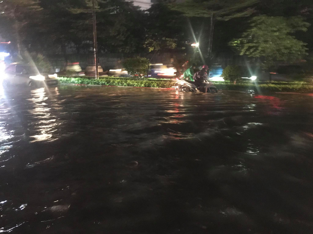 Đường Trần Thái Tông (Cầu Giấy, Hà Nội) sau gần 1 tiếng mưa to đã bị ngập úng cục bộ, xe máy, ô tô di chuyển qua đây gặp khó khăn.