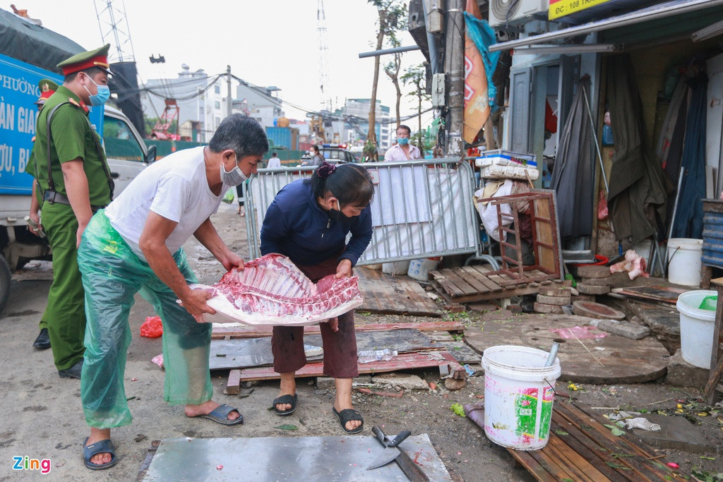 Một tiểu thương bày nguyên con lợn đã được xẻ thịt dưới lòng đường Đại La, sáng 12/5.