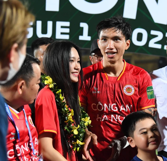 Hải My tươi cười hạnh phúc khi được Đoàn Văn Hậu đeo cho chiếc vòng kết hoa của nhà vô địch.