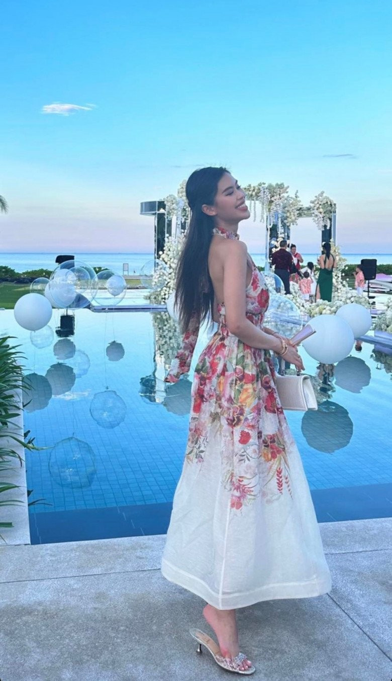 Mới đây, "con gái rượu" của Johnathan Hạnh Nguyễn vừa mới có màn "lên đồ" tham dự lễ tiệc cưới của giới siêu giàu. Trong không gian cưới xa hoa, nữ rich kid diện thiết kế đầm maxi hở lưng với họa tiết hoa văn nữ tính.