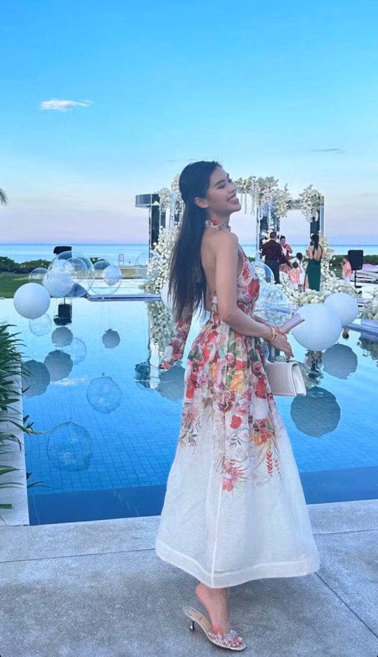 Mới đây, "con gái rượu" của Johnathan Hạnh Nguyễn vừa mới có màn "lên đồ" tham dự lễ tiệc cưới của giới siêu giàu. Trong không gian cưới xa hoa, nữ rich kid diện thiết kế đầm maxi hở lưng với họa tiết hoa văn nữ tính.