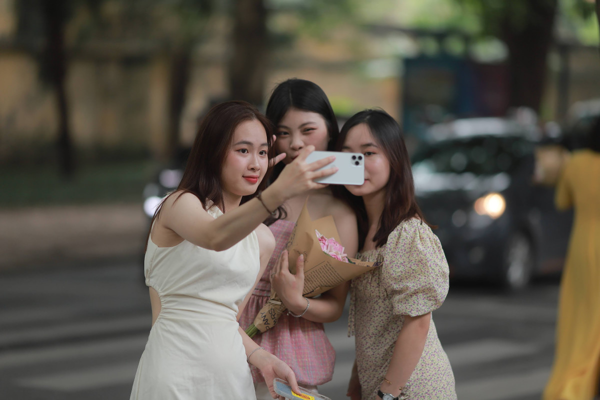 Tiết trời mát mẻ của mùa thu Hà Nội cũng là lúc những gánh hàng rong chở đầy hoa bắt đầu xuống phố tấp nập hơn. Nhiều cô gái xinh đẹp xúng xính váy áo để chụp ảnh kỷ niệm trong tiết trời đẹp nhất trong năm.