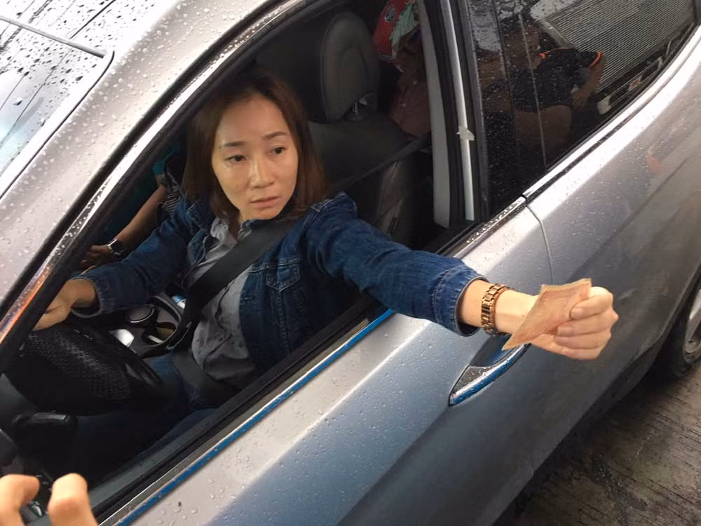 Nữ tài xế sử dụng tiền lẻ mệnh giá thấp để mua vé qua trạm BOT Cai Lậy.