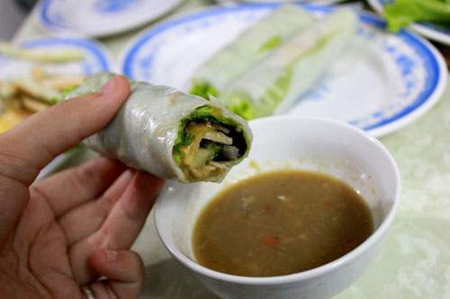 Món ăn kèm với bánh tráng là rau ghém. Rau được chia làm hai loại là rau xanh và các loại quả thái lát mỏng như dứa, chuối xanh, xoài xanh...tạo nên hương vị rất đặc trưng cho các món cuốn Việt Nam. Một suất ăn ở quán sẽ là 40.000 đồng cho những thực khách lựa chọn thịt heo luộc làm nguyên liệu chính để cuộn. Còn 50.000 đồng là giá suất thịt heo quay. Vào những ngày bỗng dưng muốn đổi khẩu vị, bạn có thể đến đây thưởng thức món bánh tráng cuộn tươi ngon này. (Ảnh: Moncuonngon).