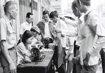 Vỡ òa trước niềm vui thống nhất đất nước, các hiệu may trong Thành phố Đà Nẵng đưa máy khâu ra hè phố may cờ cách mạng cho nhân dân treo trong ngày giải phóng, từ chối nhận tiền công. Ảnh: Nhà báo Đinh Quang Thành.
