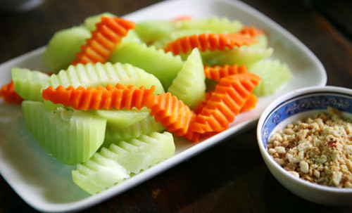 Món phụ 1: Củ quả luộc chấm muối vừng. Su su và cà rốt luộc chấm với muối vừng mằn mặn, vừa đơn giản mà lại rất ngon lành. Để thực hiện món ăn này bạn đun một lượng nước sao nhiều một chút, khi nước sôi bạn cho ít muối vào nồi nước luộc và cho củ quả cắt miếng vừa ăn vào nồi. Luộc đến khi bạn dùng đũa xiên được qua củ quả như vậy là củ quả đã chín, bạn chuẩn bị một bát nước lọc sạch, thả thêm 1,2 viên đá rồi vớt củ quả luộc ra thả ngay vào bát nước lạnh để củ quả giữ được màu xanh.