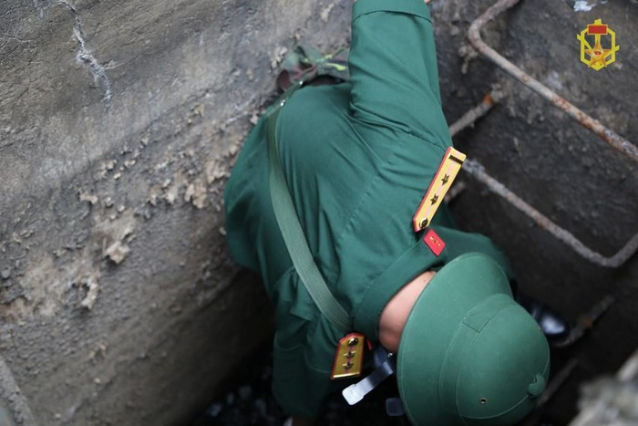 Một cán bộ đang thu thập mẫu vật từ trong rãnh thoát nước thải của Công ty Rạng Đông. Theo các chuyên gia, nước thải từ khu nhà xưởng có thể mang thủy ngân hòa vào các dòng sông chứa nước thải của thành phố