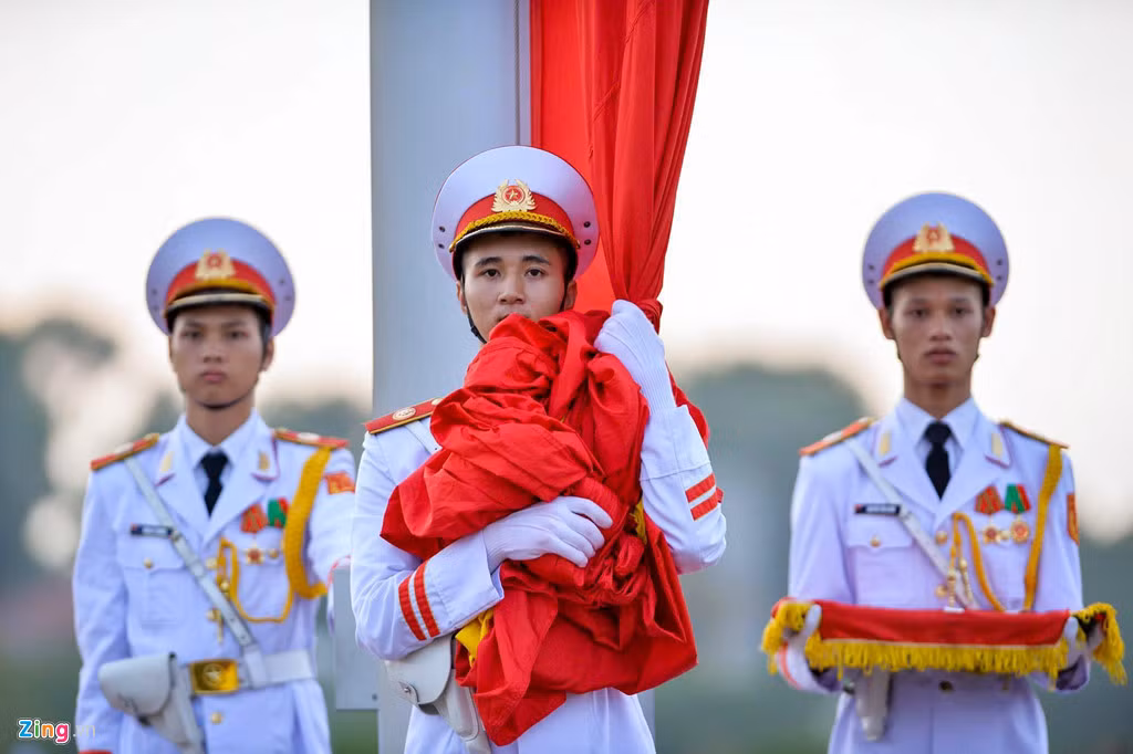 Thượng cờ là nghi lễ cấp quốc gia được thực hiện mỗi ngày vào lúc 6h mùa hè và 6h30 mùa đông. Người dân khi đi qua Quảng trường Ba Đình đều đứng trang nghiêm. Ảnh: Việt Hùng.