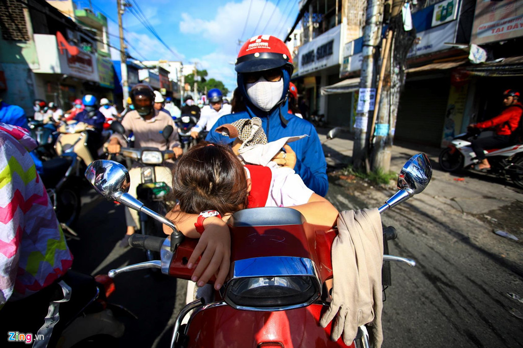 Một em học sinh chờ lâu dưới ánh nắng gay gắt nằm gục xuống xe. Chị Nguyệt cho biết ngày nào cũng mất hơn 15 phút để di chuyển qua đoạn đường vài trăm mét đưa con tới trường. Hình ảnh dòng xe cộ xếp hàng dài, nhích từng chút để thoát các tuyến đường ở cửa ngõ phía tây bắc TP.HCM phổ biến vào giờ cao điểm mỗi ngày. Ảnh: Quỳnh Danh.