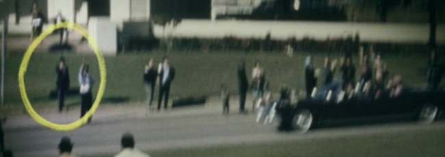 Người này bị hoài nghi có liên quan đến vụ ám sát là vì ngày hôm đó là một ngày đẹp trời, không cần dùng tới ô. Chính vì vậy, một số người đưa ra giả thuyết người cầm ô đã ra dấu hiệu cho hung thủ Oswald nã đạn vào Tổng thống Kennedy.