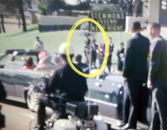Không chỉ xuất hiện trong các bức ảnh, một số nhân chứng cho hay nhìn thấy một người đàn ông "khả nghi" cầm ô khi xe chở Tổng thống Kennedy đi ngang qua.