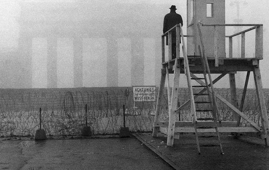 Một người lính làm nhiệm vụ tại tháp canh ở cổng Brandenburg để phát hiện và ngăn chặn những người có hành vi vượt qua Bức tường Berlin.