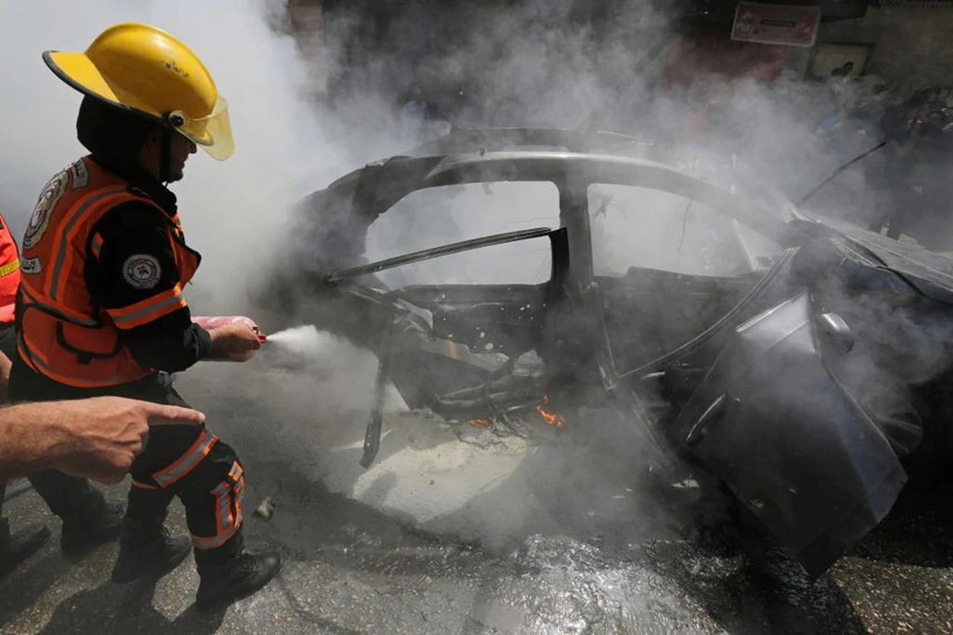 Lính cứu hỏa Palestine cố gắng dập lửa cho chiếc xe của một chỉ huy Hamas thiệt mạng do máy bay Israel công kích, các nhân vật cấp cao của nhóm Hồi giáo vũ trang này là mục tiêu thường xuyên của quân đội Israel. Ảnh: Reuters.