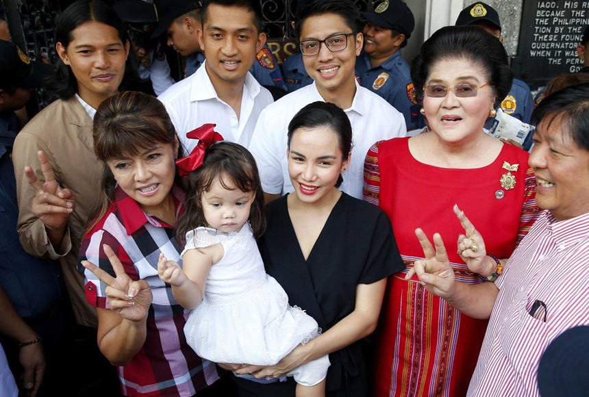 Điều này dẫn tới sự trở lại sân khấu chính trị của nhà Marcos. Imee Marcos, con gái lớn của nhà độc tài Ferdinand Marcos cũng có mặt trong danh sách ứng viên thượng nghị sĩ. Người phụ nữ mặc áo đỏ chính là bà Imelda Marcos, cựu đệ nhất phu nhân Philippines. Ảnh: AP.
