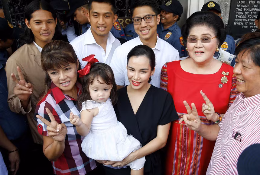 Điều này dẫn tới sự trở lại sân khấu chính trị của nhà Marcos. Imee Marcos, con gái lớn của nhà độc tài Ferdinand Marcos cũng có mặt trong danh sách ứng viên thượng nghị sĩ. Người phụ nữ mặc áo đỏ chính là bà Imelda Marcos, cựu đệ nhất phu nhân Philippines. Ảnh: AP.
