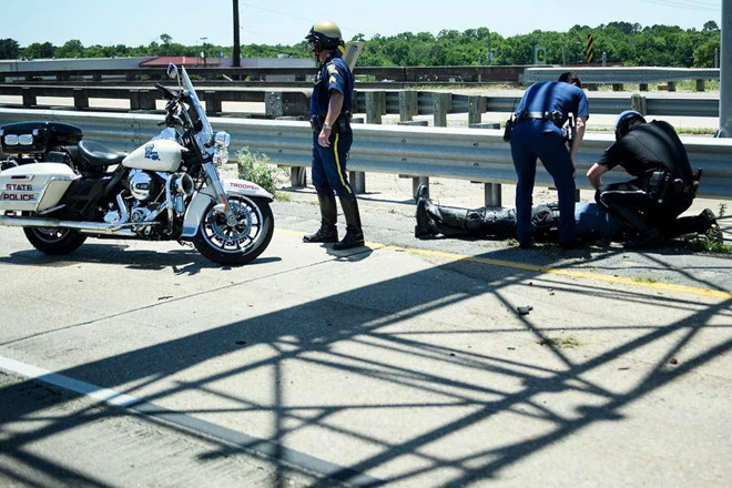 Cảnh sát thành phố Lake Charles và Nhà Trắng cho biết trong các tuyên bố riêng rằng 3 sĩ quan đã bị thương. Trong ảnh, các cảnh sát đang hỗ trợ một người bị thương. Ảnh: AFP.