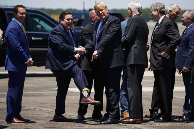 Phát ngôn viên Sở mật vụ Mason Brayman viết trong một tuyên bố gửi qua email rằng một sĩ quan cảnh sát Westlake cũng bị vướng vào vụ tai nạn. Cảnh sát thành phố Lake Charles đang phối hợp với cảnh sát bang Louisiana điều tra nguyên nhân vụ việc. Trong ảnh, Phó thống đốc bang Louisiana Billy Nungesser khoe chiếc tất in hình Tổng thống Trump khi ông bắt tay nhà lãnh đạo Mỹ tại Sân bay Quốc tế Chennault. Ảnh: AP.