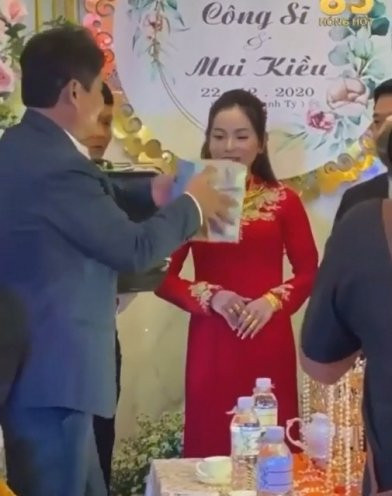 Theo dõi đoạn video, có thể thấy, bố của cô dâu không ngần ngại xách cả vali tiền lên sân khấu và chia thành từng xấp để trao tặng cho con gái kèm theo đó là nhiều giấy chứng nhận về quyền sở hữu nhà đất. Ảnh: Tổng hợp