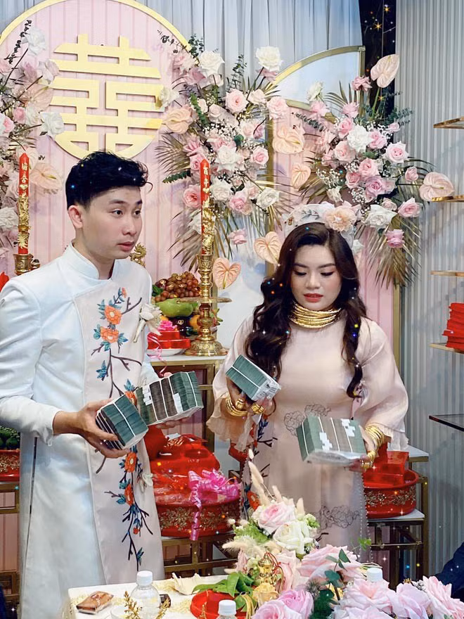 Trong ngày cưới, cô dâu nở nụ cười rạng rỡ khoe cổ, cổ tay, ngón tay đeo chi chít lắc, nhẫn, kiềng vàng.