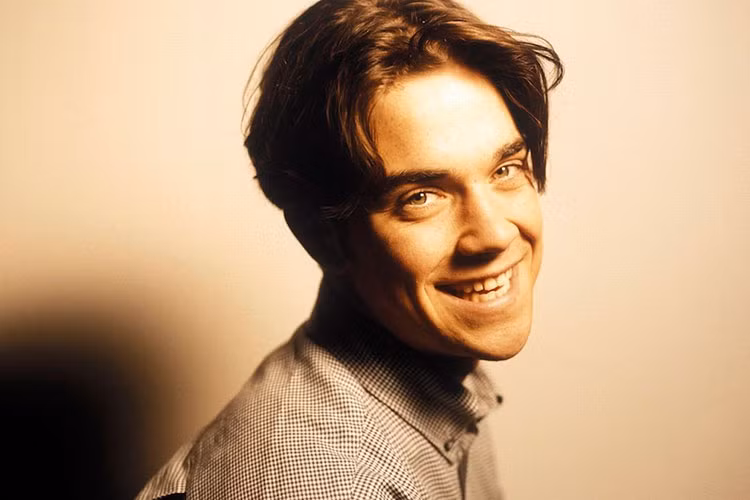 Robbie sinh năm 1974, tại Anh quốc. Khi còn ngồi trên ghế nhà trường, anh được bạn bè, thầy cô biết đến nhờ năng khiếu ca hát, diễn xuất. Ảnh: Themirror