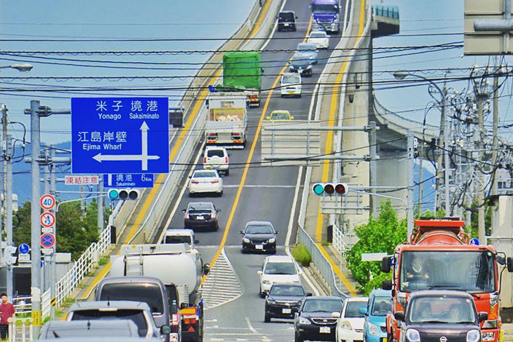 Cầu Eshima Ohashi, Nhật Bản: Eshima Ohashi không phải con đường mà chính xác là một cây cầu. Cây cầu dài 1.7 km và rộng 12 m, nối hai thành phố Matsue và Sakaiminato. Cây cầu với thiết kế cao cho phép những tàu thuyền kích thước lớn có thể di chuyển thoải mái, nhưng lại đem đến cái nhìn chót vót cho một cây cầu bình thường.