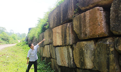 Ông Nguyễn Bá Linh - Phó Giám đốc Trung tâm bảo tồn di sản Thành nhà Hồ đang chỉ những điểm tường thành bị phình ra, có nguy cơ sụp xuống bất cứ lúc nào. Ảnh: HĐ