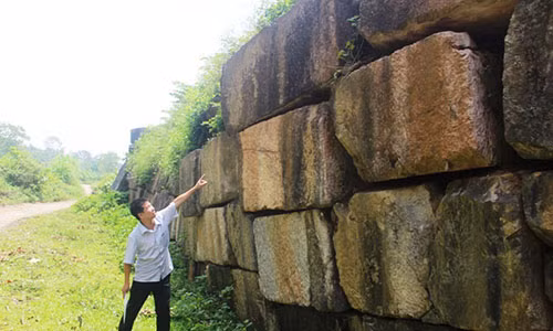 Ông Nguyễn Bá Linh - Phó Giám đốc Trung tâm bảo tồn di sản Thành nhà Hồ đang chỉ những điểm tường thành bị phình ra, có nguy cơ sụp xuống bất cứ lúc nào. Ảnh: HĐ