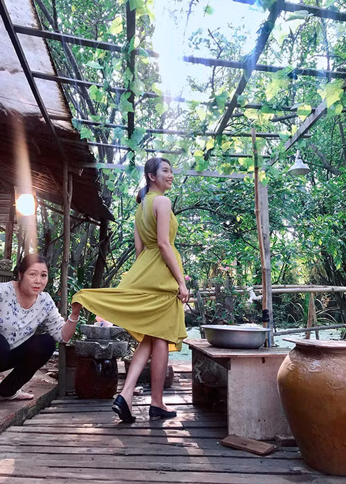 Hình ảnh nghệ sĩ Hồng Vân nâng váy cho Thúy Ngân trên phim trường.