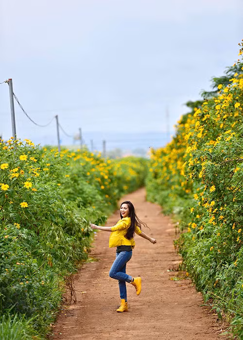 Bà mẹ một con Hiền Thục tung tăng trên con đường hoa nở vàng rực.