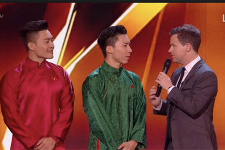 Quốc Cơ - Quốc Nghiệp mặc áo dài lắng nghe nhận xét từ ban giám khảo sau khi trình diễn. Ảnh: Express